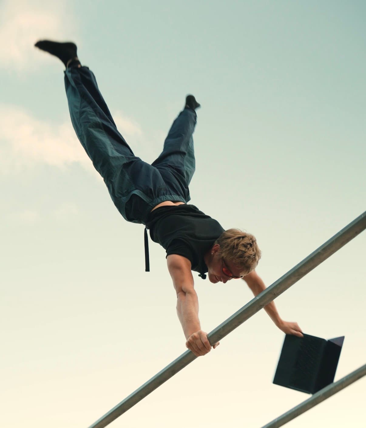 Stefan practicing a handstand on an outdoor bar